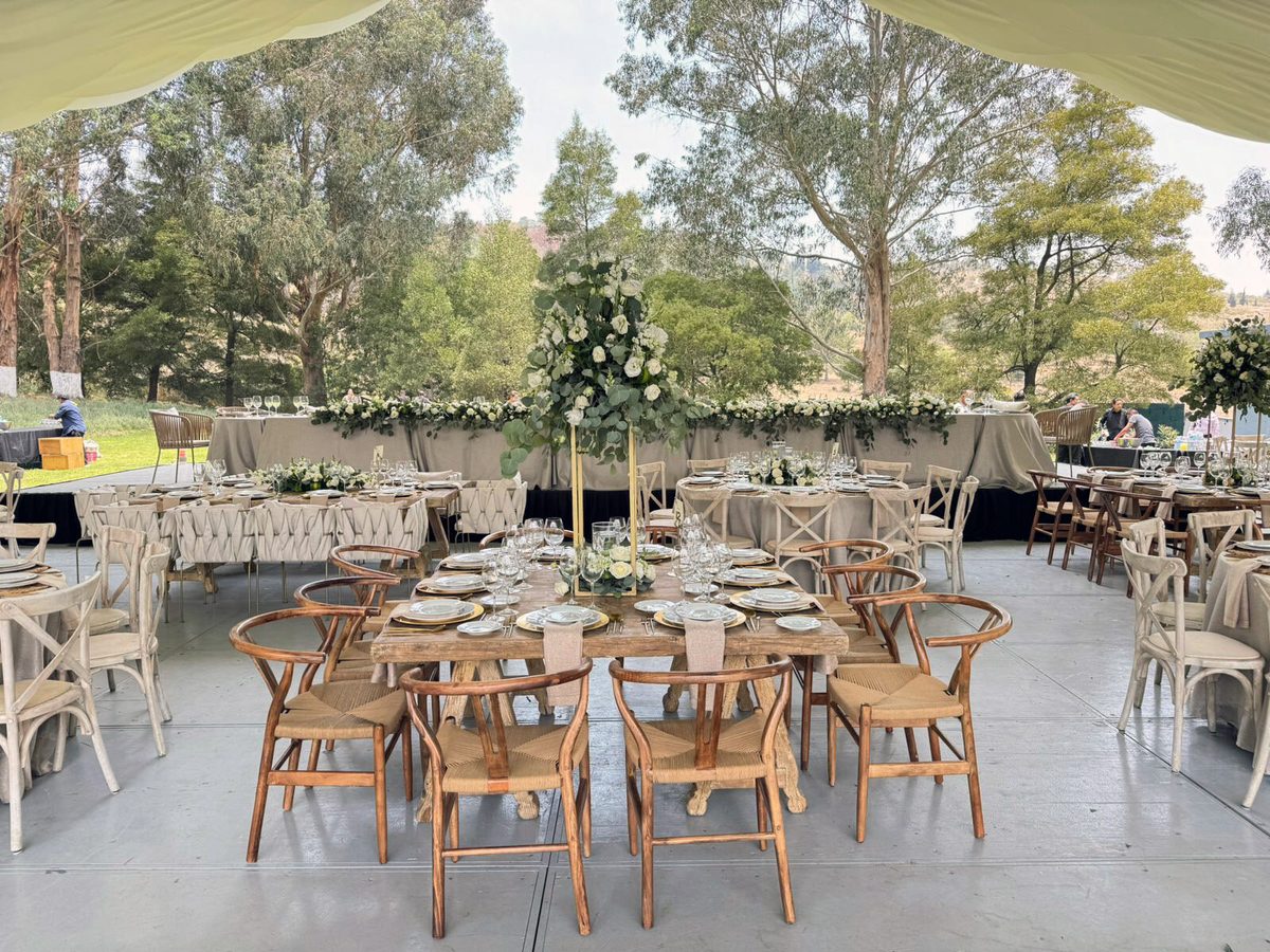 Montaje de boda al aire libre con mesas y flores blancas en los jardines