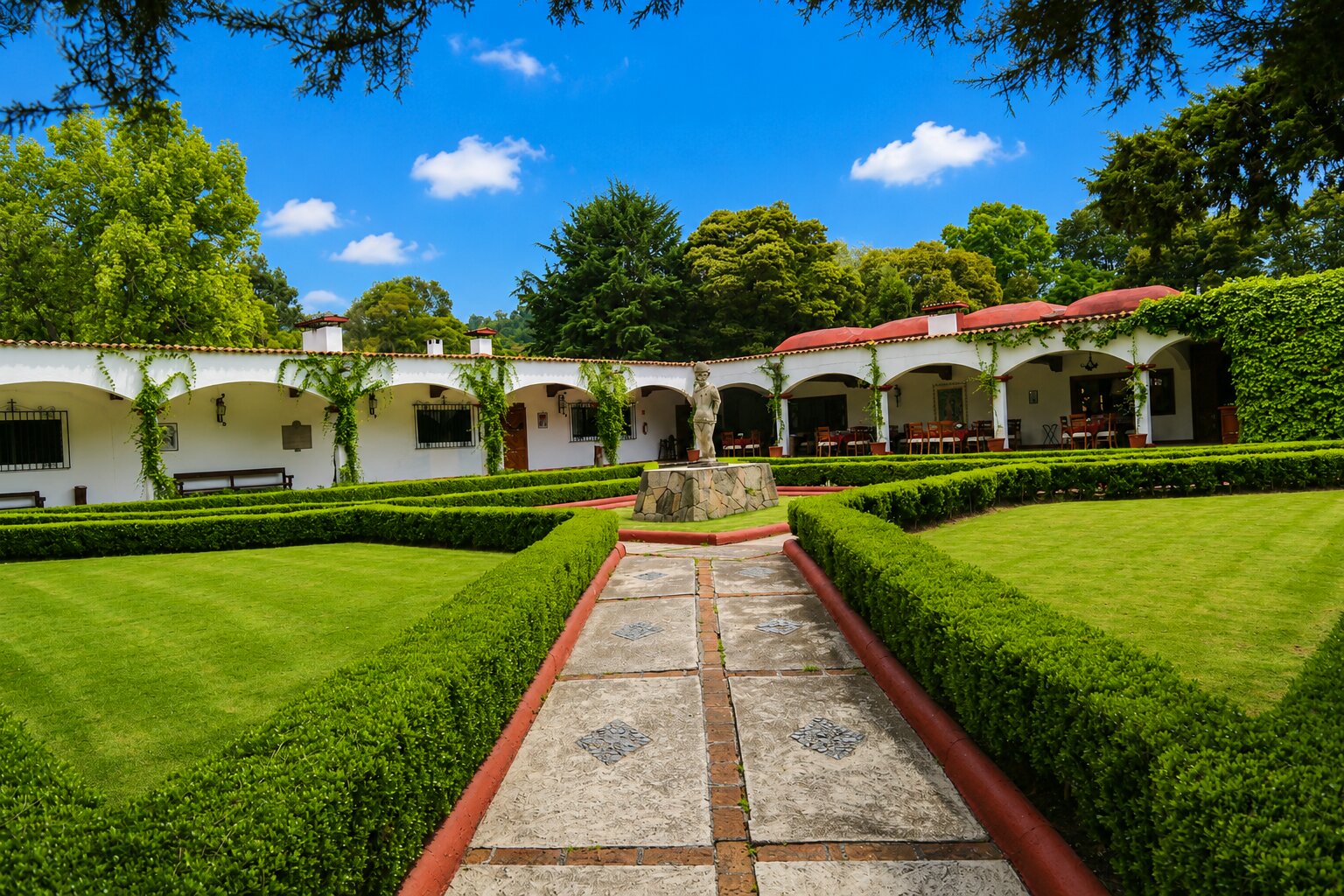 Casco histórico de la Hacienda La Purísima con jardines, arcos y la escultura de Cantinflas